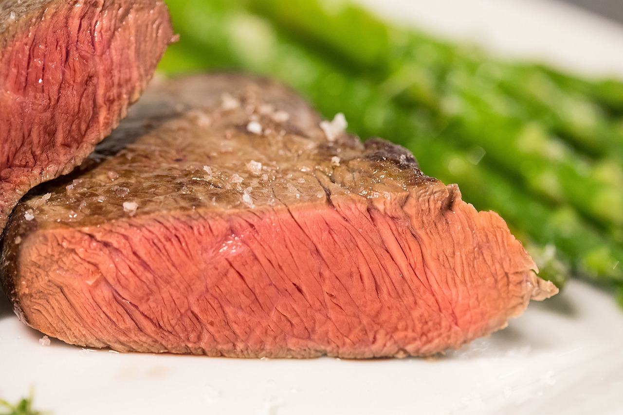 Image of Raw Tri Tip on Cutting Board: "Raw tri tip steak on a wooden cutting board, trimmed and ready for seasoning.