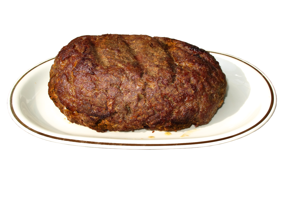Main Dish Image: "A slice of juicy, budget-friendly slow-cooked meatloaf on a plate with mashed potatoes and green beans, garnished with fresh parsley." Ingredients Image: "Simple ingredients for slow-cooked meatloaf, including ground beef, breadcrumbs, eggs, onion, and seasonings arranged on a kitchen countertop." Preparation Step Image: "Hands mixing ground beef, breadcrumbs, and seasonings in a large bowl to prepare the meatloaf mixture." Slow Cooker Image: "Slow cooker with raw meatloaf mixture shaped into a loaf, ready to cook on low for 5 hours." Final Presentation Image: "Sliced slow-cooked meatloaf served on a plate with a side of mashed potatoes, perfect for a budget-friendly family meal." Close-up of Meatloaf Texture: "Close-up of the juicy texture of slow-cooked meatloaf, showcasing the moist and tender beef."