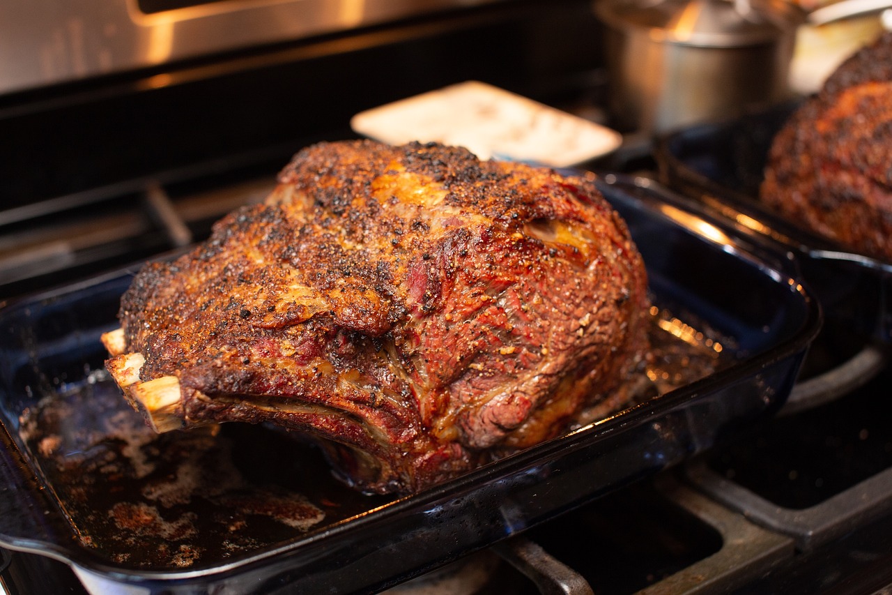Smoked prime rib roast resting on a wooden cutting board with fresh rosemary and garlic