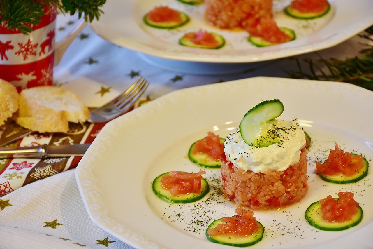 Fresh Salmon Tartare with chives, dill, sesame seeds, and diced avocado, presented in a round mold with vibrant colors."