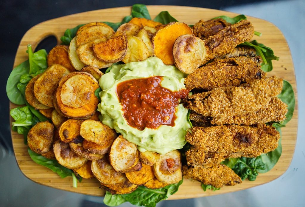 Assorted crispy baked vegetables on a baking sheet – A colorful array of roasted vegetables, including carrots, zucchini, and bell peppers, spread in a single layer on a parchment-lined baking sheet.