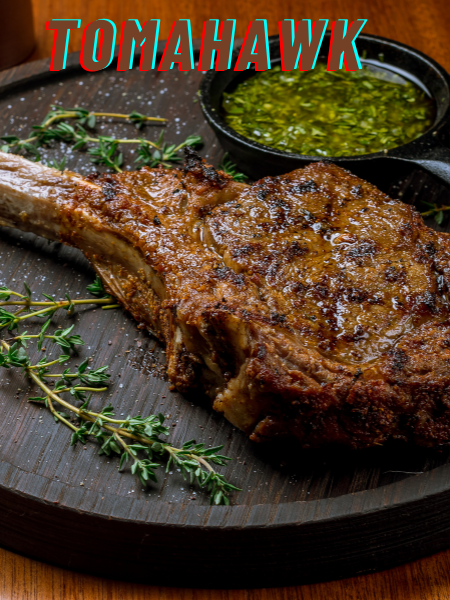 Tomahawk steak served on a plate with the large rib bone on display, surrounded by fresh herbs
