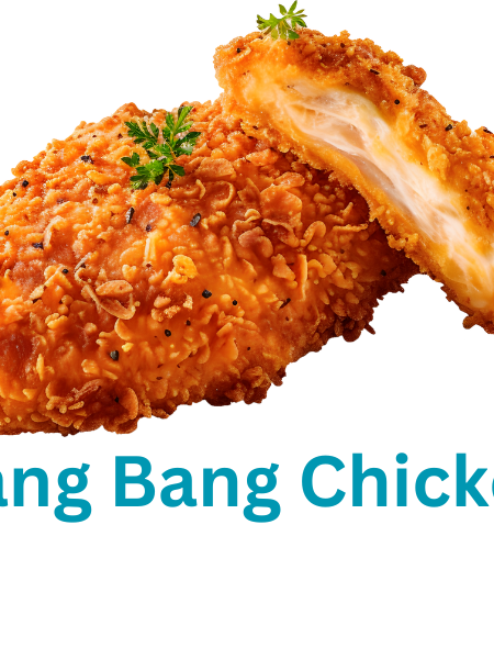 A plate of golden, crispy Bang Bang Chicken bites topped with creamy, spicy sauce and garnished with green onions.