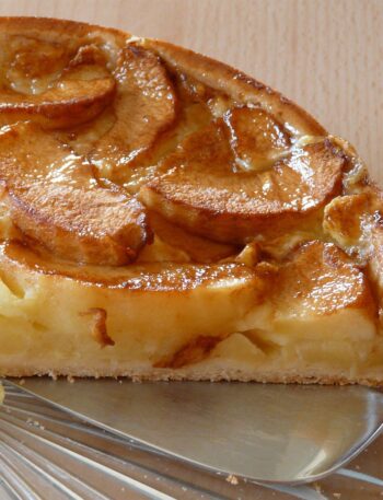 "Freshly baked apple pie with a golden, flaky crust and a beautifully arranged apple filling.