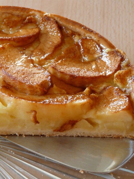 "Freshly baked apple pie with a golden, flaky crust and a beautifully arranged apple filling.